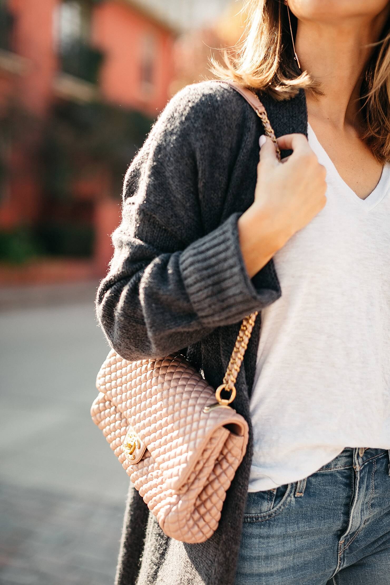 pink quilted Chanel bag with white tee and grey cardigan