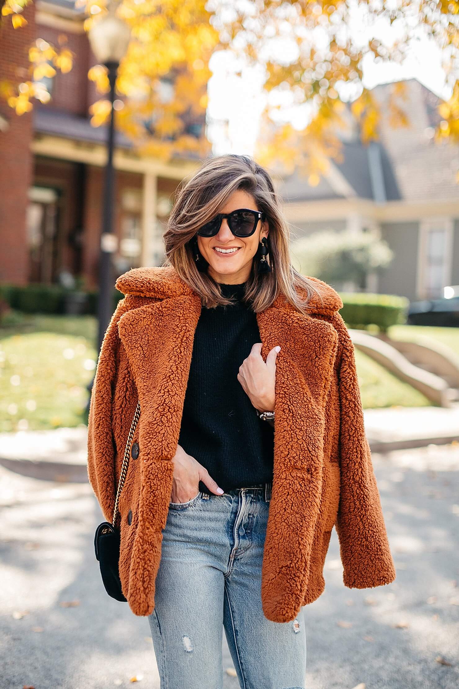 orange teddy coat, black sweater, distressed levi jeans, leopard pumps and gucci cross body 