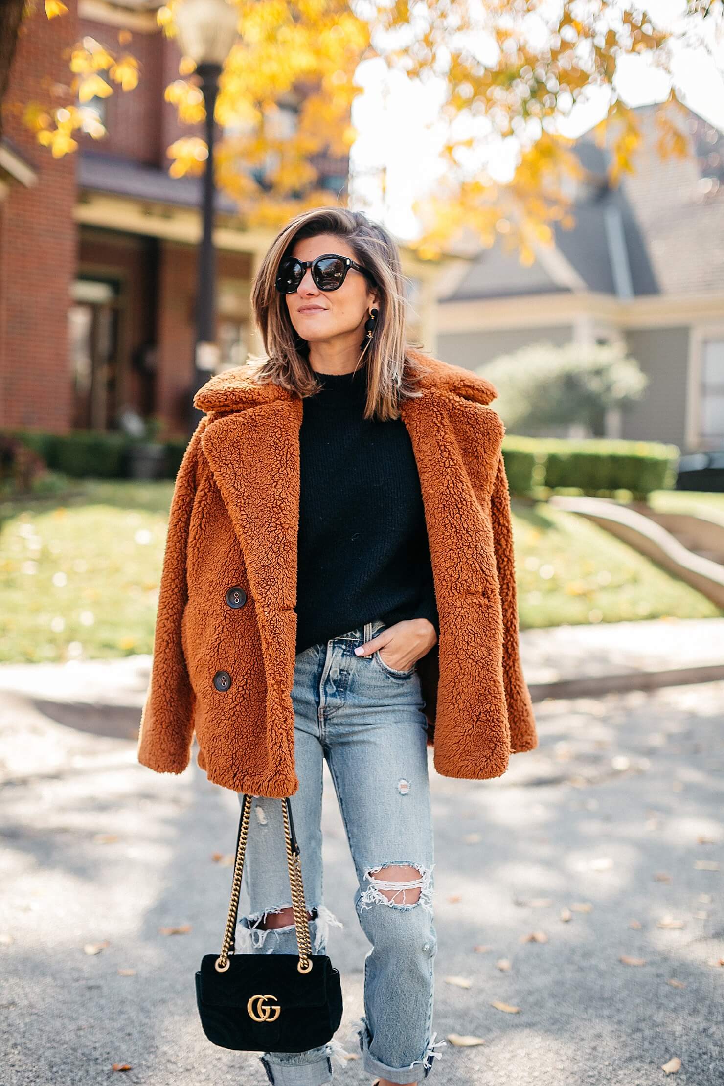 orange teddy coat, black sweater, distressed levi jeans, leopard pumps and gucci cross body 