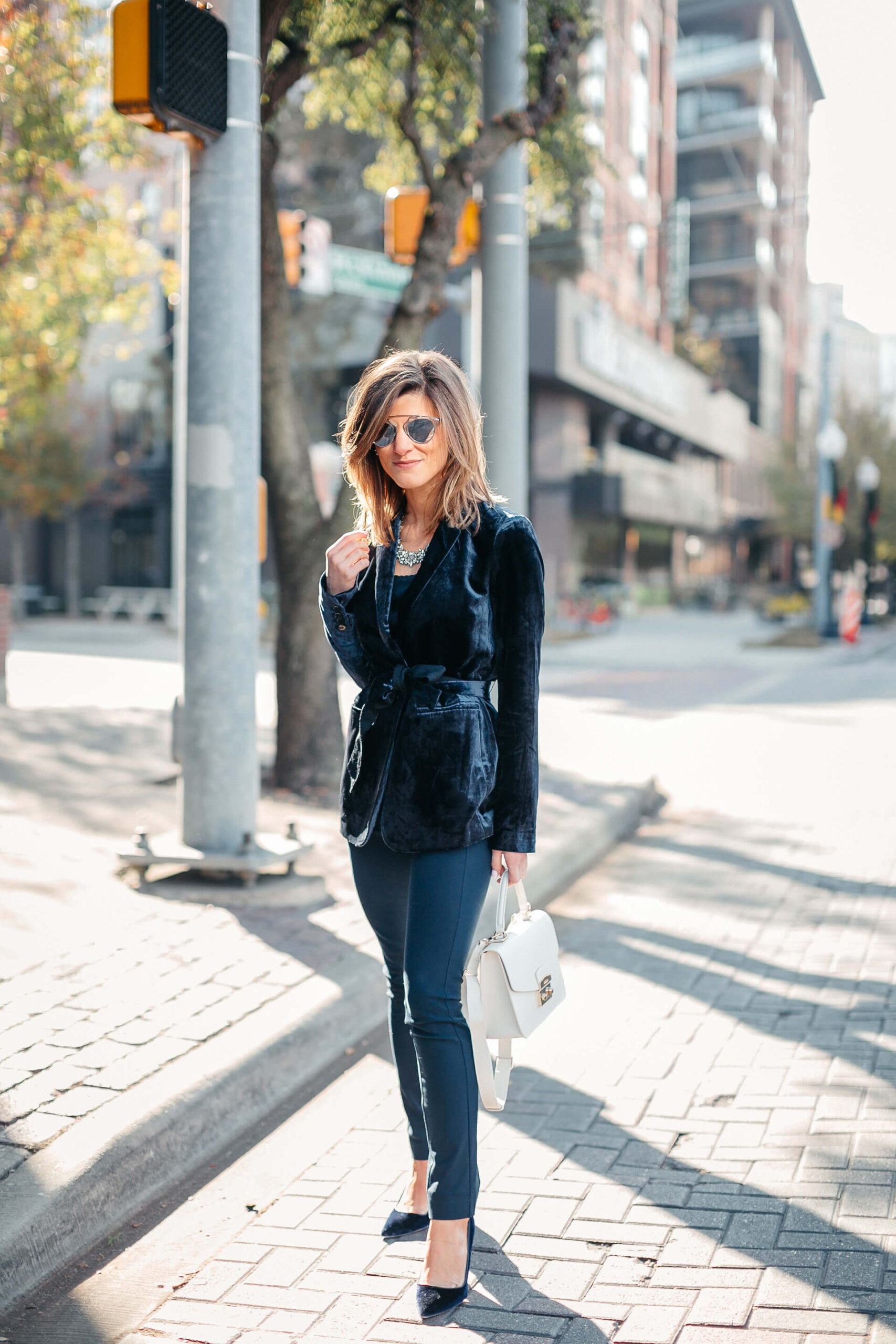 Navy jacket, camisole, blue simone pants, blue velvet pumps, and statement jewelry, dior sunglasses, white furla bag 