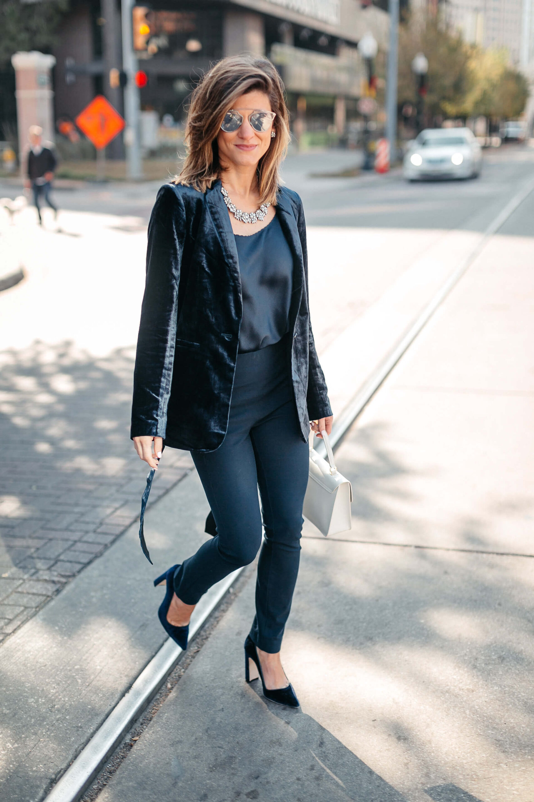 Navy jacket, camisole, blue simone pants, blue velvet pumps, and statement jewelry, dior sunglasses, white furla bag 