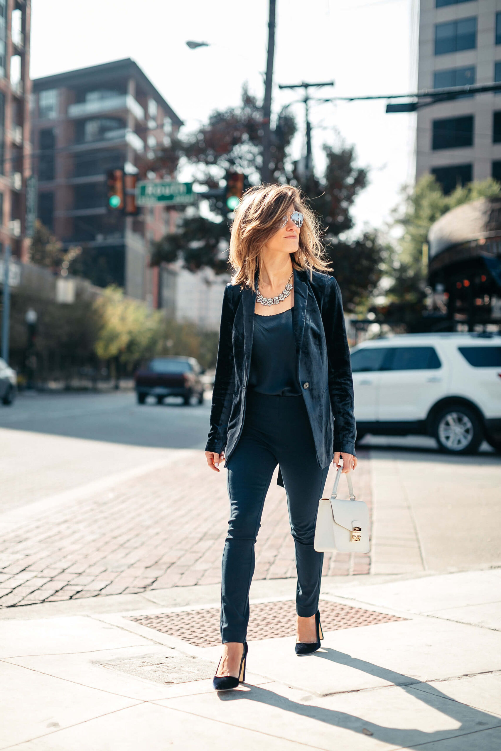 Navy jacket, camisole, blue simone pants, blue velvet pumps, and statement jewelry, dior sunglasses, white furla bag 