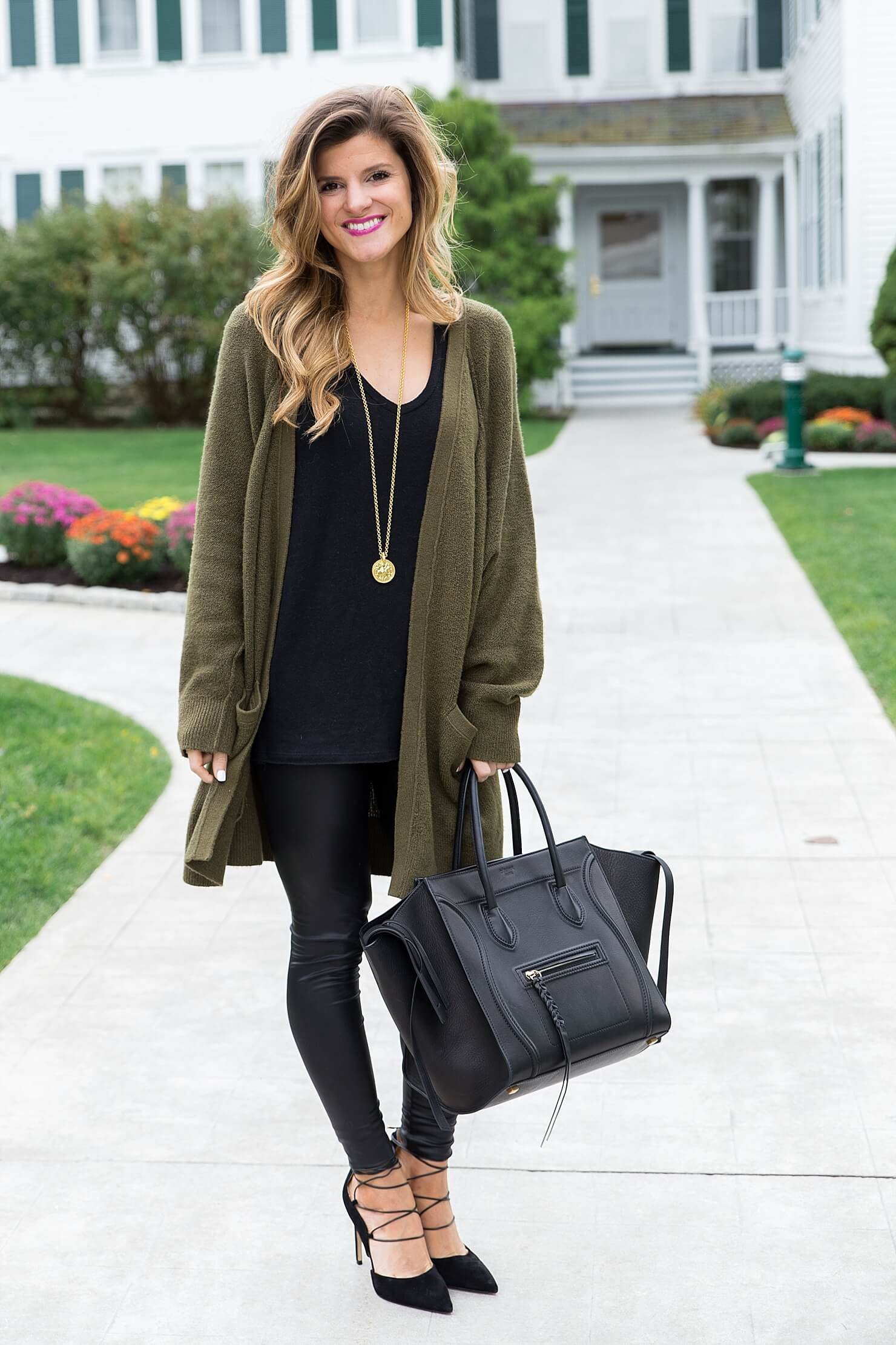 all black outfit idea, wearing all black with a long olive cardigan, liquid leather leggings winter outfit, black on black outfit, going out winter outfit, winter date night outfit, celine phantom tote, sam edelman strappy heels, winter all black outfit