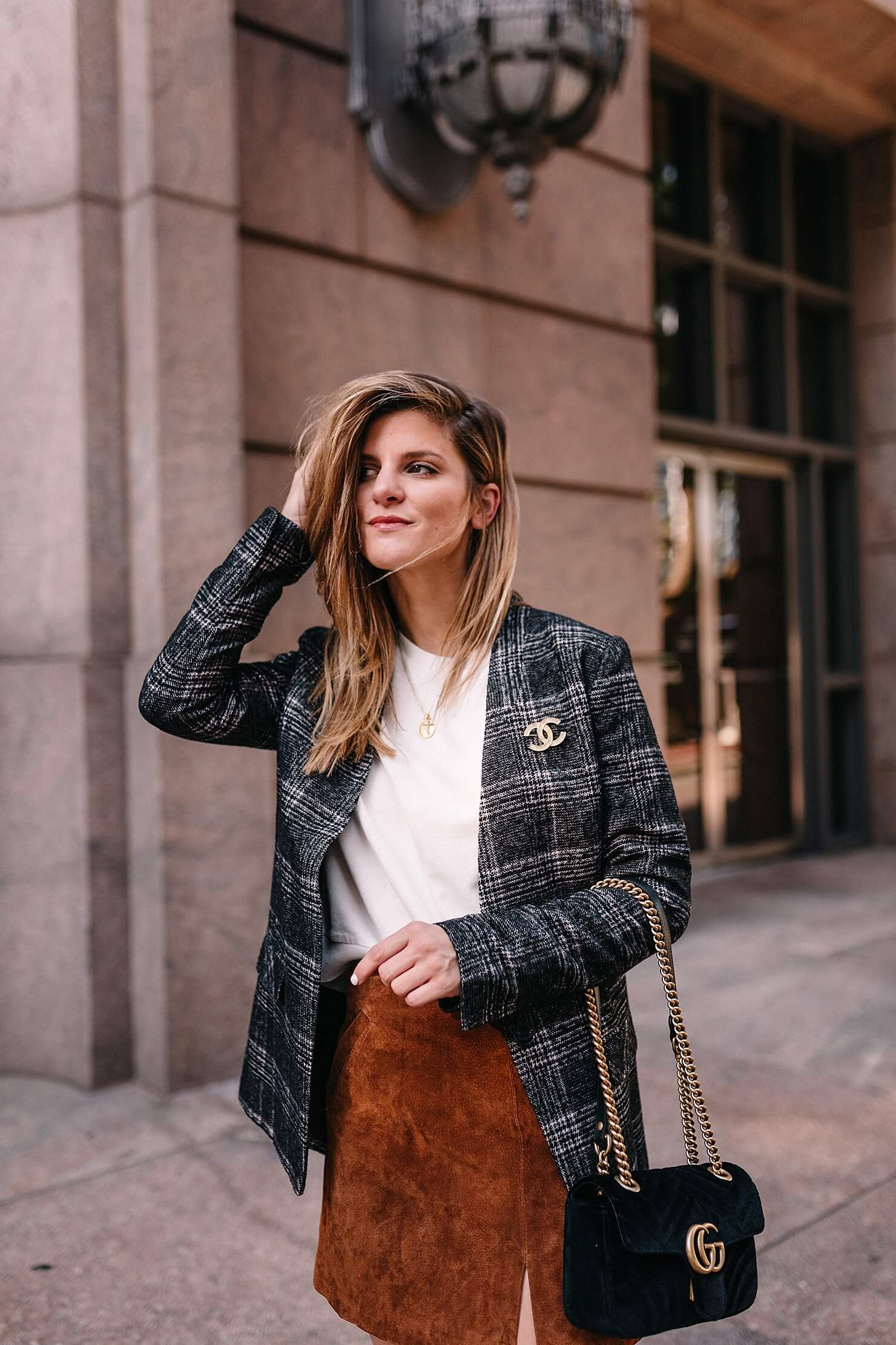 plaid blazer detail shot with gucci black velvet marmont bag and chanel vintage pin on blazer