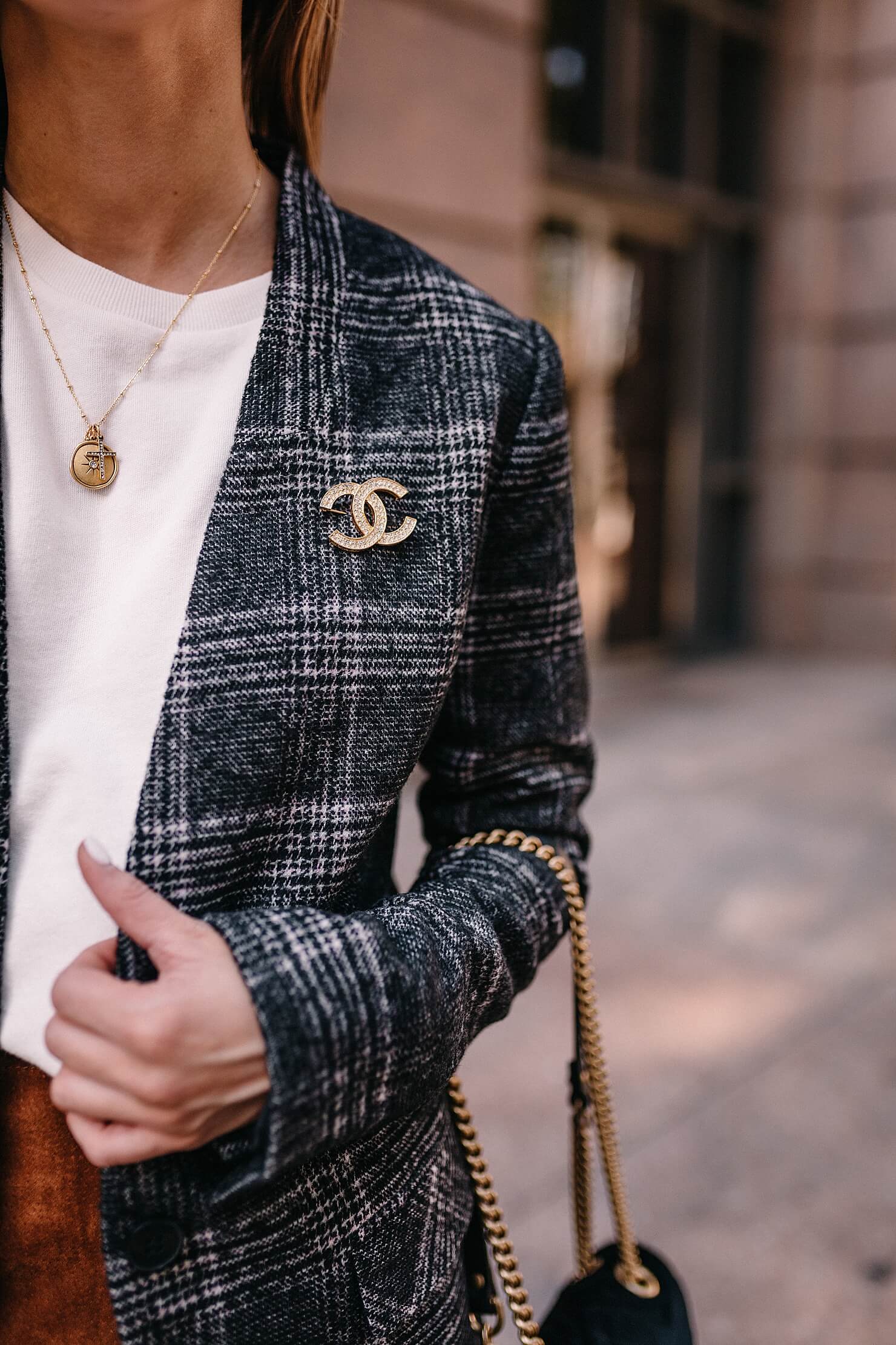 plaid blazer detail shot with gucci black velvet marmont bag and chanel vintage pin on blazer