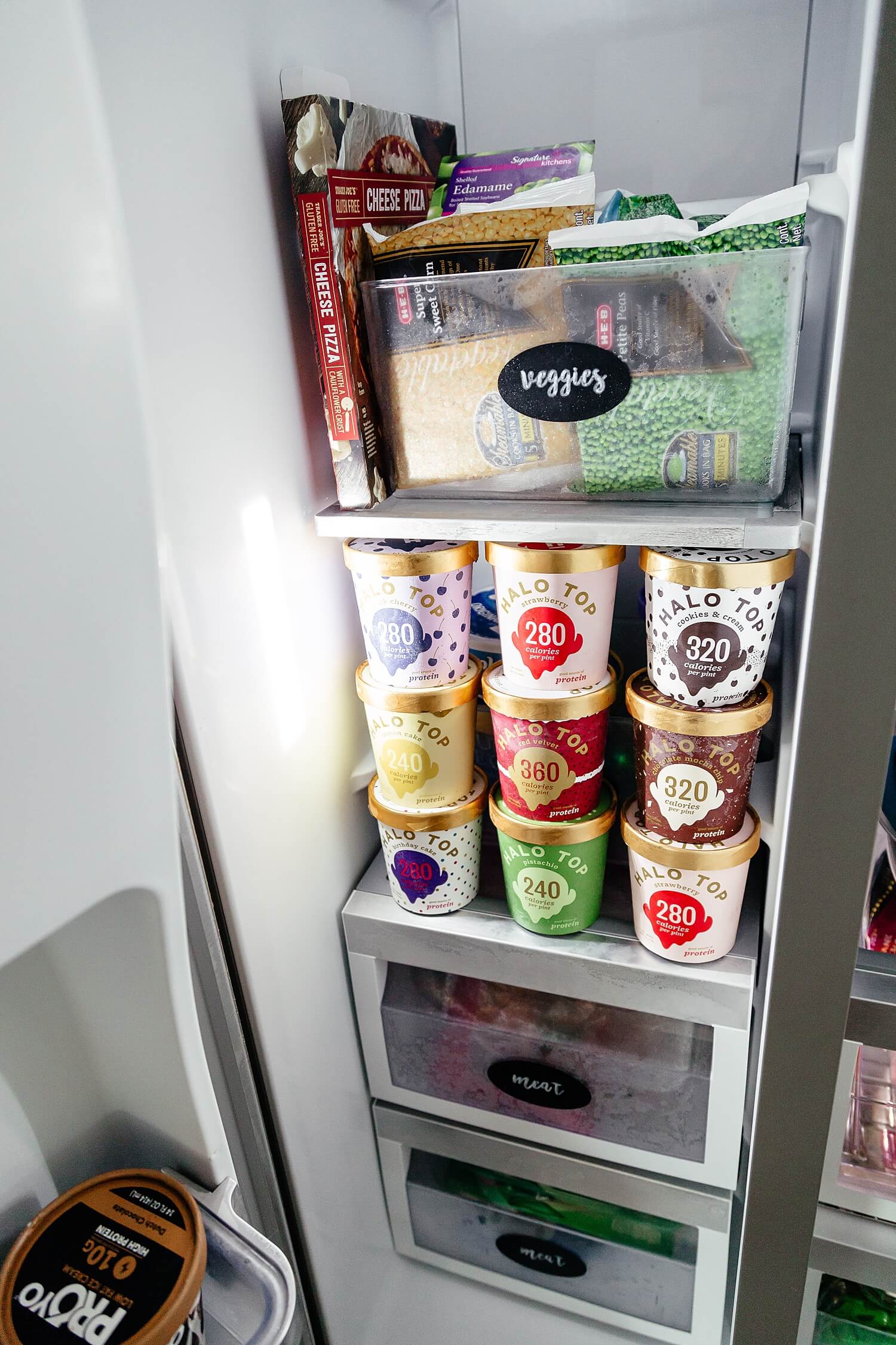 organized freezer with cursive labels on freezer containers