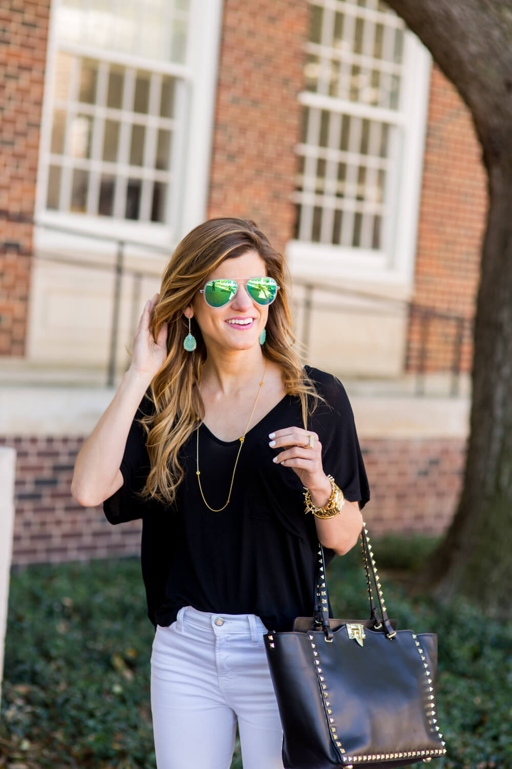 white jeans outfit with a simple black tee, delicated layered gold necklaces, white jeans dressed up with black tee, white jeans with pointed toe pumps, white jeans and black tee outfit, valentino rockstud bag, casual laid back chic outfit, going out outfit, summer style, white jeans going out outfit